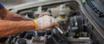 Mains de mécanicien travaillant sur un moteur de voiture